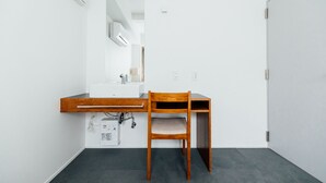 Un baño pequeño y moderno con una silla de madera, un lavabo blanco y un espejo.