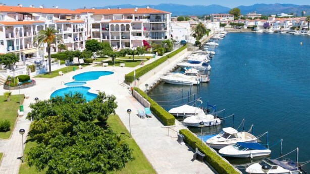 A hotel with a swimming pool, a marina with boats, and a view of the sea and mountains. - Sant Maurici by Interhome (Empuriabrava)