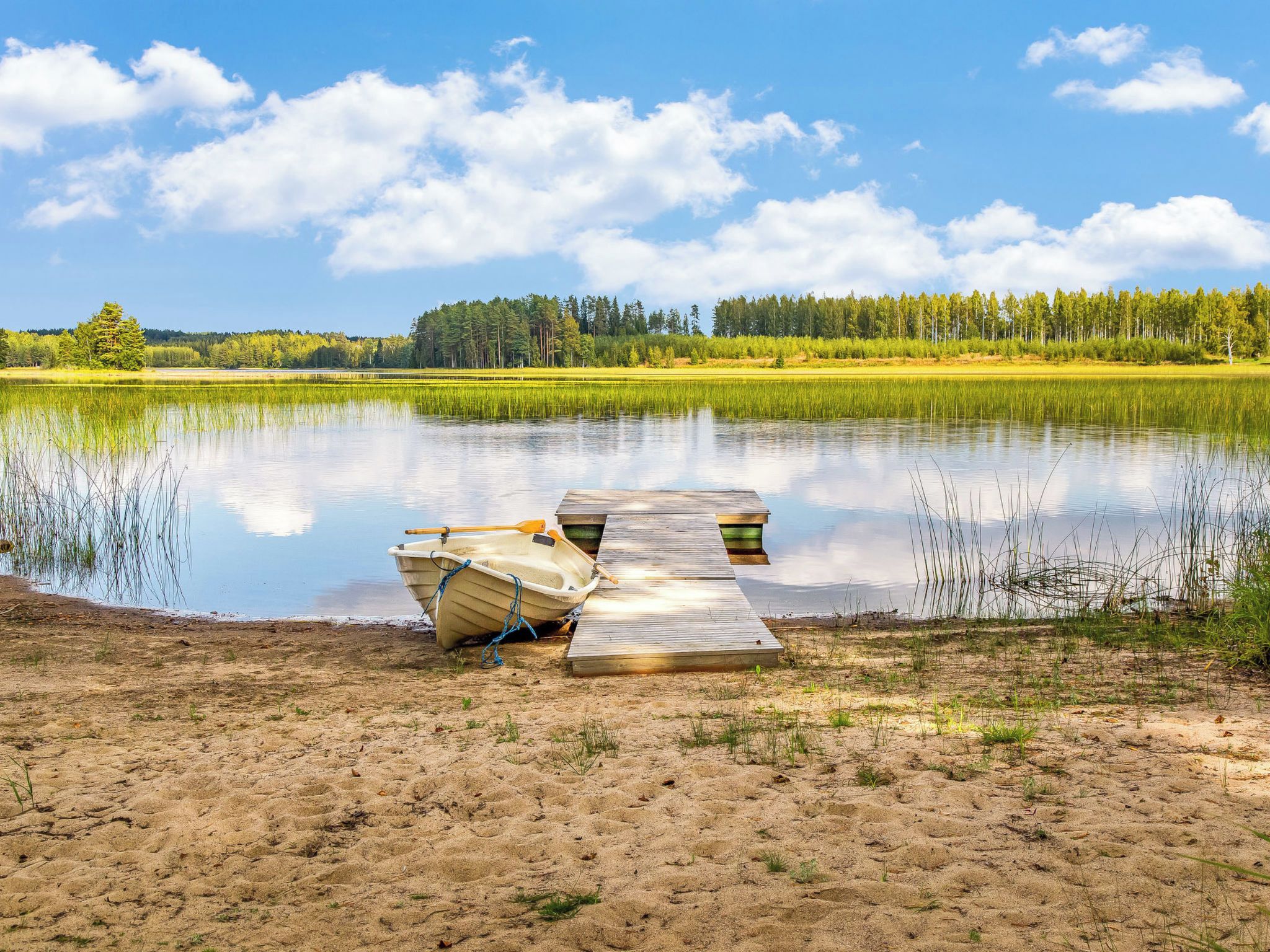 A calm lake with a wooden dock and two boats.