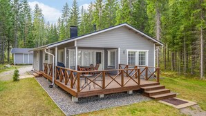 A cabin with a covered deck, outdoor seating, and a gravel driveway. - Vacation home Kaisla by Interhome (Heinola)