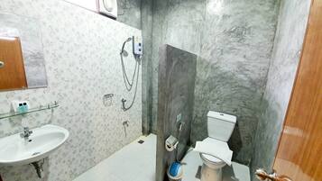 A bathroom with a sink, toilet, shower, and a towel rack.