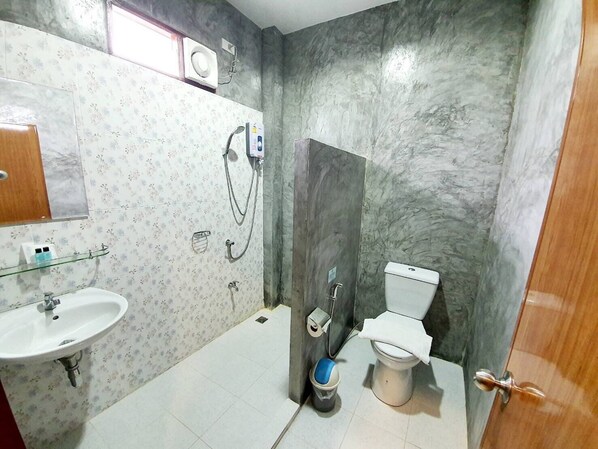 Un baño con lavabo, inodoro, ducha y toallero.