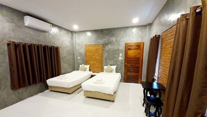 Een hotelkamer met twee bedden, een klein tafeltje en een stoel.