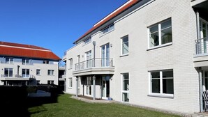 A modern building with a flat roof, large windows, and a small balcony. - Dünenblick apartment DBL02, house 1 (Ostseebad Boltenhagen)