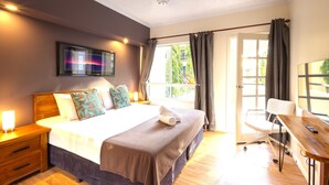 Une chambre à coucher comprenant un lit, une table de chevet et un bureau avec une chaise.