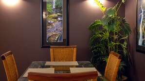 Un espace repas comprenant une table, des chaises et une grande plante en pot.