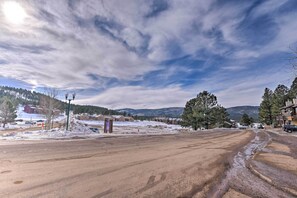 Eine weite, offene Straße mit blauem Himmel und fernen Bergen.