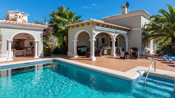 Zona junto a la piscina con piscina, mobiliario exterior y un porche cubierto.