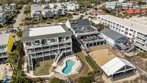 Un hôtel situé sur la côte, doté de nombreux balcons, d’une piscine et d’un espace de plage.