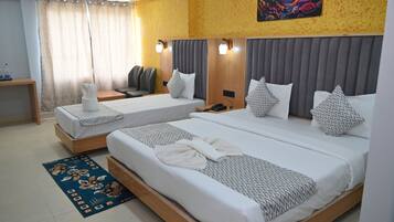 Una habitación de hotel con dos camas, un escritorio, una silla y una mesita de noche.