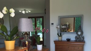 Una habitación con mostrador de madera, plantas en macetas, lámpara, espejo y un armario.