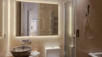 Een bad/douchecombinatie, een haardroger, handdoeken, zeep