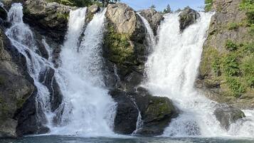 A waterfall cascading over rocky terrain with clear water at the base.
