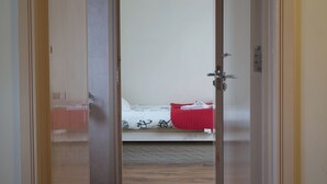 A room with a bed, a door, and a wooden floor. - The homely Mourne lodge (kilkeel)
