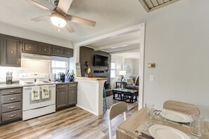 Enjoy meals in the kitchen with a stove and microwave, accompanied by a large flat-screen TV above the fireplace.