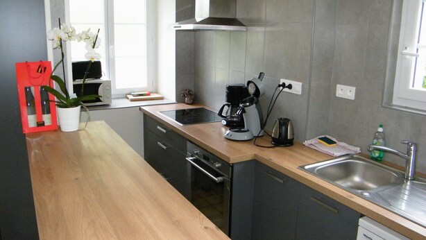 Eine moderne Küche mit Holzauskauf, Edelstahlgeräten und einem eingebauten Backofen.