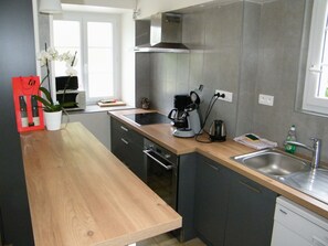 A modern kitchen with a wooden countertop, stainless steel appliances, and a built-in oven.