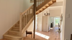 A wooden staircase leading to an upper floor, a door, a kitchen area, and a tiled floor. - House 200 m2 for 11 people with heated swimming pool. (STE ANNE SUR VILAINE)