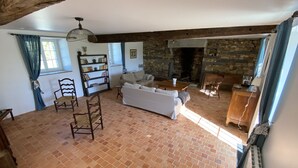 A spacious living room with a fireplace, a bookshelf, and a cozy seating area. - House 200 m2 for 11 people with heated swimming pool. (STE ANNE SUR VILAINE)