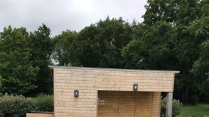 A swimming pool with four lounge chairs and a wooden building with a covered area. - House 200 m2 for 11 people with heated swimming pool. (STE ANNE SUR VILAINE)