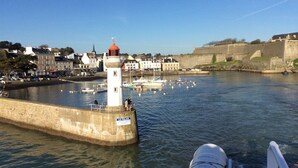 Ein Hafen mit Leuchtturm, Booten und einer Steinmauer.
