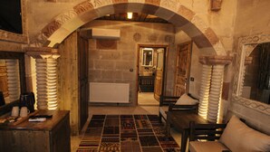 A traditional interior with a patterned rug, wooden furniture, and stone walls. - Wonder of Cappadocia (Nevsehir)