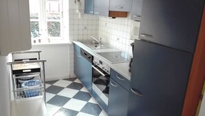 A kitchen with blue cabinets, a white sink, and a black oven. - Rungholtstr. 3 a, apt. jetsam (Wyk auf Föhr)
