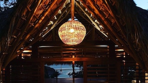A wooden building with a thatched roof and a large, spherical hanging light fixture. - Verdad Nicaragua Beach Hotel & Retreat (San Juan del Sur)