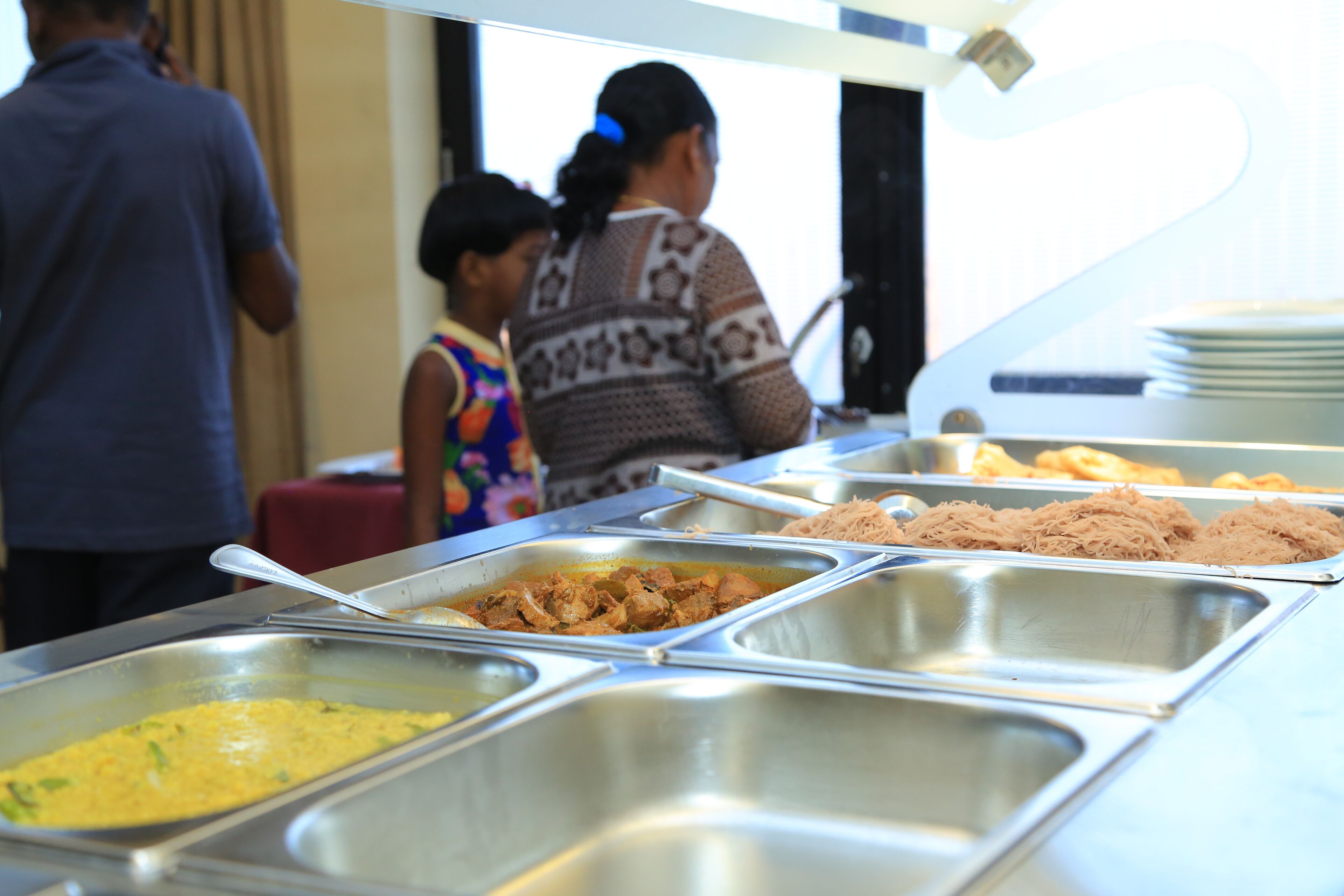 A buffet with various food options in metal trays.