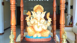 A wooden-framed statue of a deity with a blue base. - PJ Hotels Jaffna (Valikamam East)