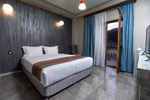 Una habitación de hotel moderna con una cama grande, un revestimiento de madera y un balcón con cortinas azules.