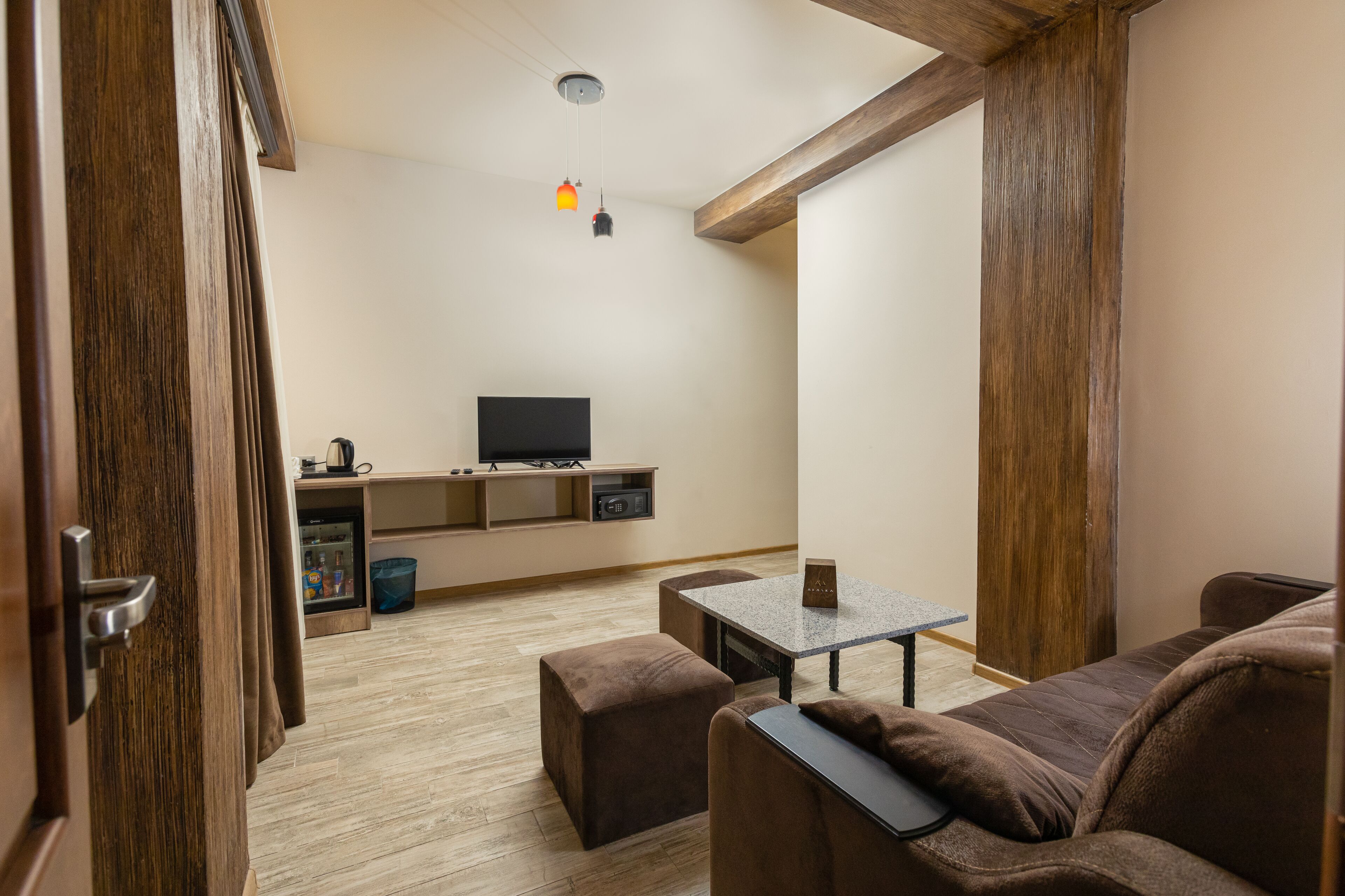 Un espacio habitable compacto con kitchenette, televisor, una mesita y sofá.