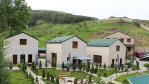 Zona residencial con tres casas, cada una de un estilo arquitectónico diferente, rodeada de césped cuidado y árboles.