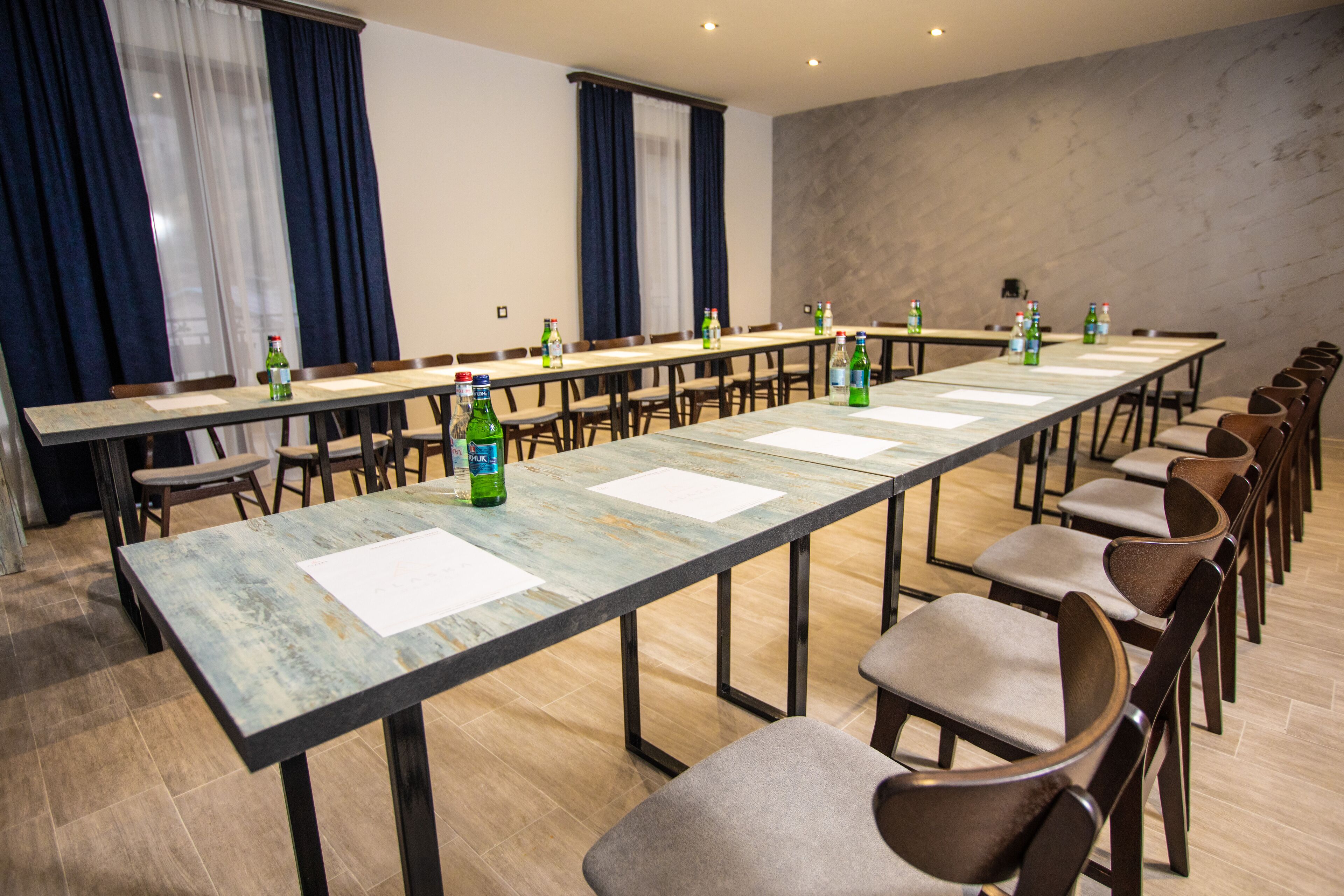 A conference room with a long table, chairs, and bottles of water.