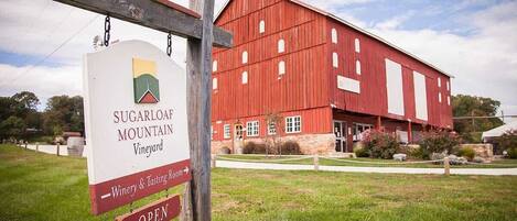 Una cascina rossa con un cartello per Sugarloaf Mountain Vineyard.