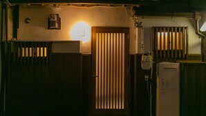 Una habitación tenuemente iluminada con una puerta de madera, un radiador y un pequeño calentador.