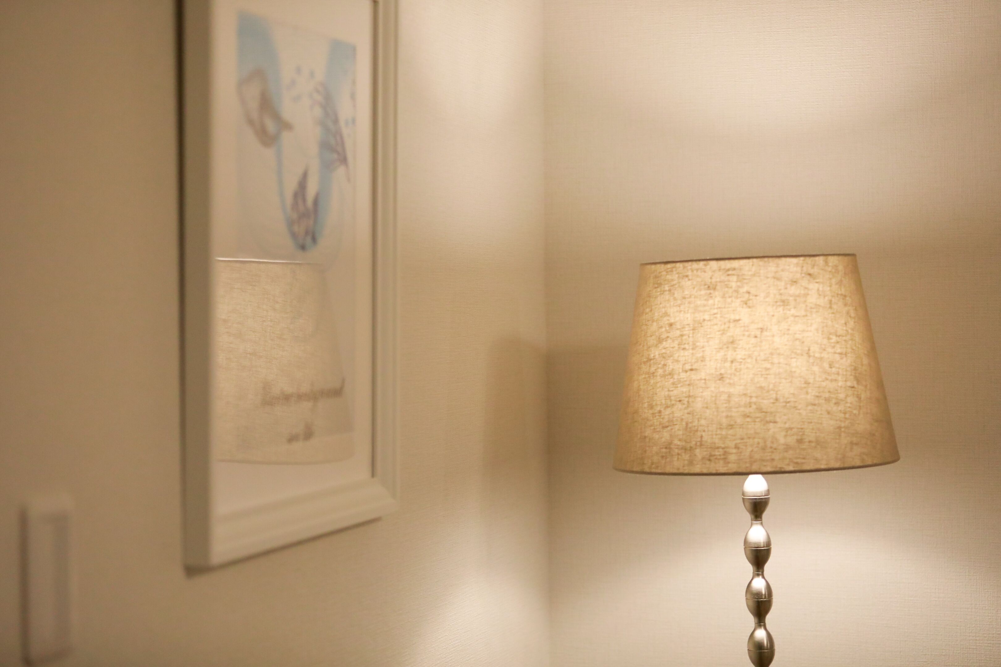 A wall-mounted lamp with a textured lampshade and a decorative base.