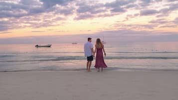 On the beach, white sand, sun loungers, beach umbrellas
