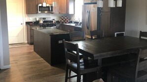 A modern kitchen with wooden cabinets, stainless steel appliances, and a central island. - 12 minutes to PennState (Bellefonte)