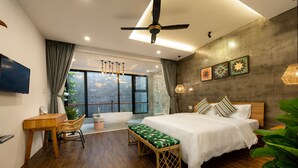 Een moderne slaapkamer met een groot bed, een bureau en een zithoek.