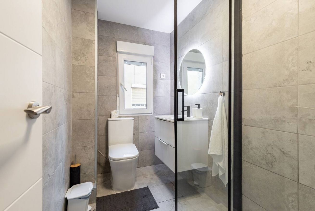 Ein modernes Badezimmer mit Toilette, Bidet und einer Duschkabine aus Glas.