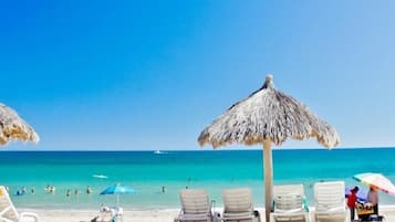 Rannalla, aurinkotuoleja, rantapyyhkeitä