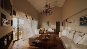 A spacious living room with a wooden coffee table, white sofas, and a chandelier. - Exclusive Seafront Villa up to 18 – Breathtaking Views & Personal Chef & Daily maid Included! (Sparto)