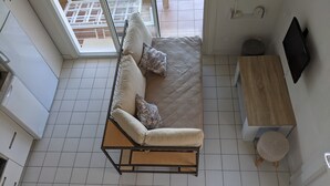 Una sala de estar moderna con un sofá, una mesita de madera y un televisor.
