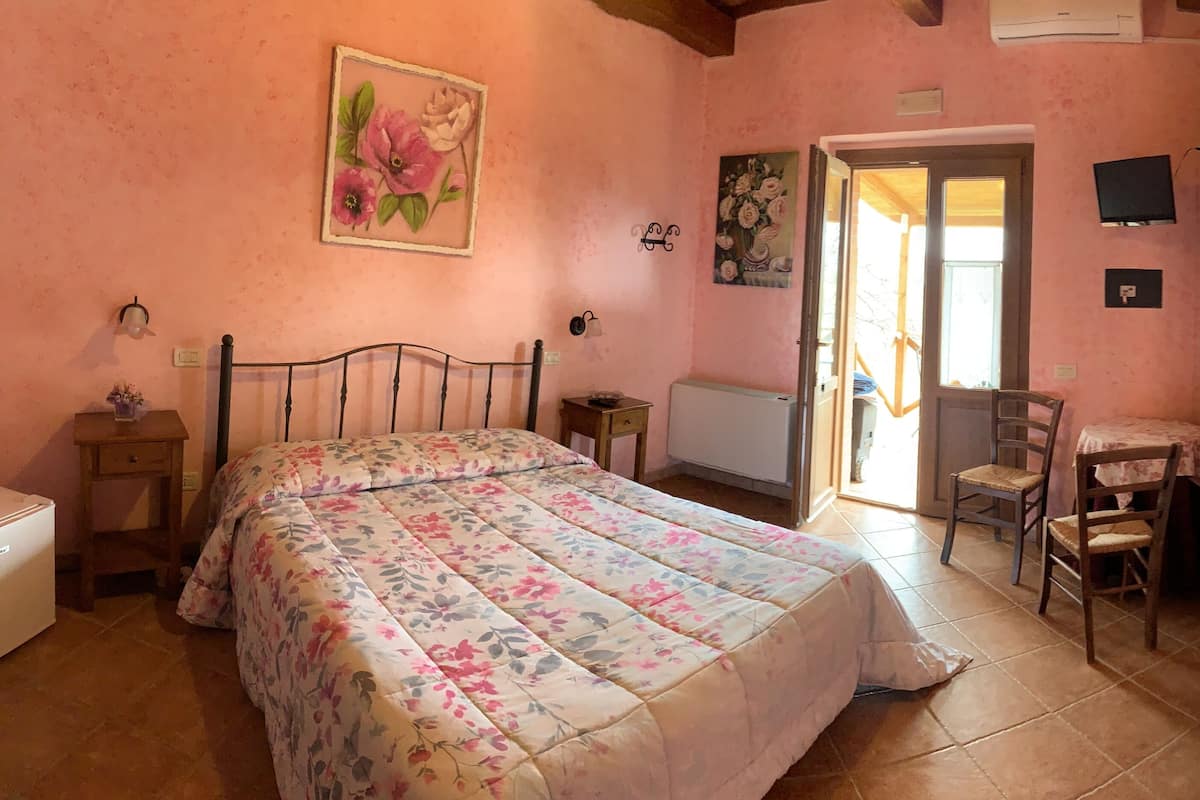 Een slaapkamer met een bed, een bureau, een stoel en een radiator.