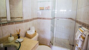 A bathroom with a glass shower enclosure, a toilet, a sink with a glass basin, and a mirror. - Exclusive oceanfront Penthouse in Miraflores with rooftop terrace (Urb Santa Cruz)