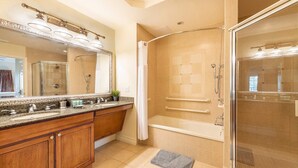 Een moderne badkamer met een dubbele wastafel, een douche met glazen wand en een grote spiegel.