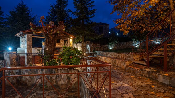 A stone courtyard with a metal staircase and a small building with a tiled roof. - Villa Kleinos: A truly magnificent villa 30 minutes from Meteora Greece (Kalambaka)