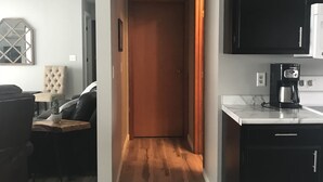 A modern kitchen with dark cabinets, a white countertop, and a coffee maker. - Oak & Arrow Cabin On Bluedog Lake, Waubay - Hunting, Fishing, Vacation (Waubay)