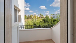Een balkon met uitzicht op een woongebied, met huizen en groen.
